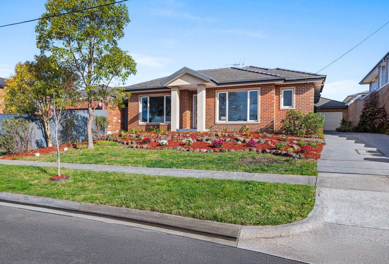 villa unit with brick exterior and neatly landscaped garden.