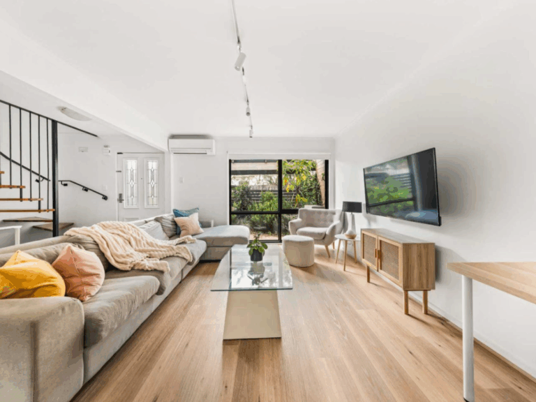 A photo of a living room in Kew, Melbourne. The room is furnished and full of natural light as it is being prepared for a real estate sales campaign.