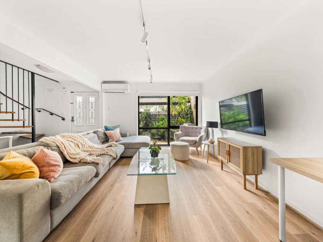 A photo of a living room in Kew, Melbourne. The room is furnished and full of natural light as it is being prepared for a real estate sales campaign.